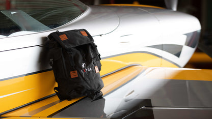 Produktbild des Extra Reiserucksacks, abgelegt auf dem rechten Flügel einer silber-gelben Extra NG.